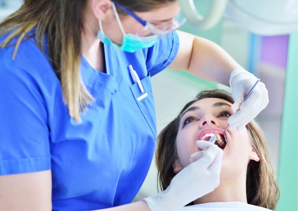 Dentist examining a patient's gums during a dental checkup to identify gingivitis symptoms, including redness, swelling, and early gum disease.